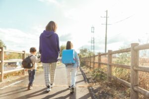 母子家庭の母親と子どもが一緒に登校する朝の風景。母子家庭が受け取れる手当や支援制度を紹介する記事のイメージ