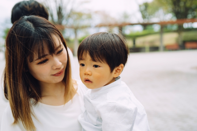 母子家庭の母親が幼い子どもを優しく抱きしめる様子。働けない時期を支える支援制度のイメージ。