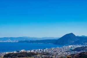 別府湾を望む大分市の街並みと高崎山の風景。母子家庭の家賃補助や住宅支援制度の記事アイキャッチ