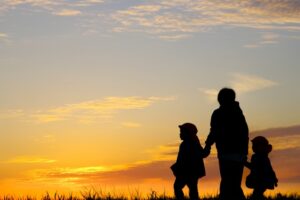 母子家庭の親子が夕暮れの中を歩くシルエット。母子家庭のメリット・デメリットや支援制度を解説する記事のイメージ。