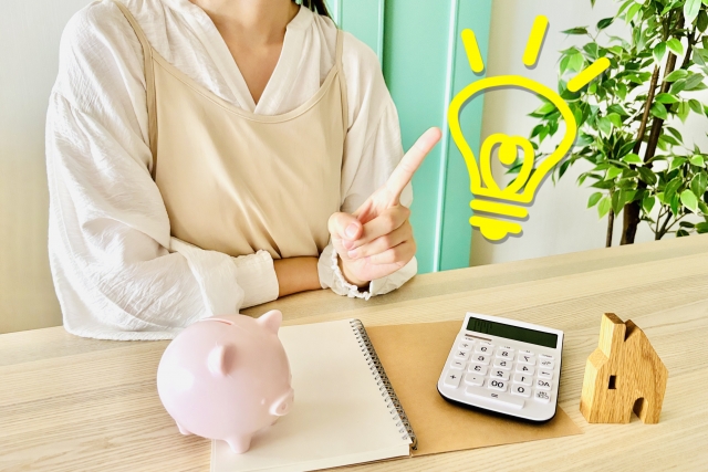 母子家庭のお母さんが家計簿と電卓を使って生活費をシミュレーションし、収入で暮らしていけるか考えている様子